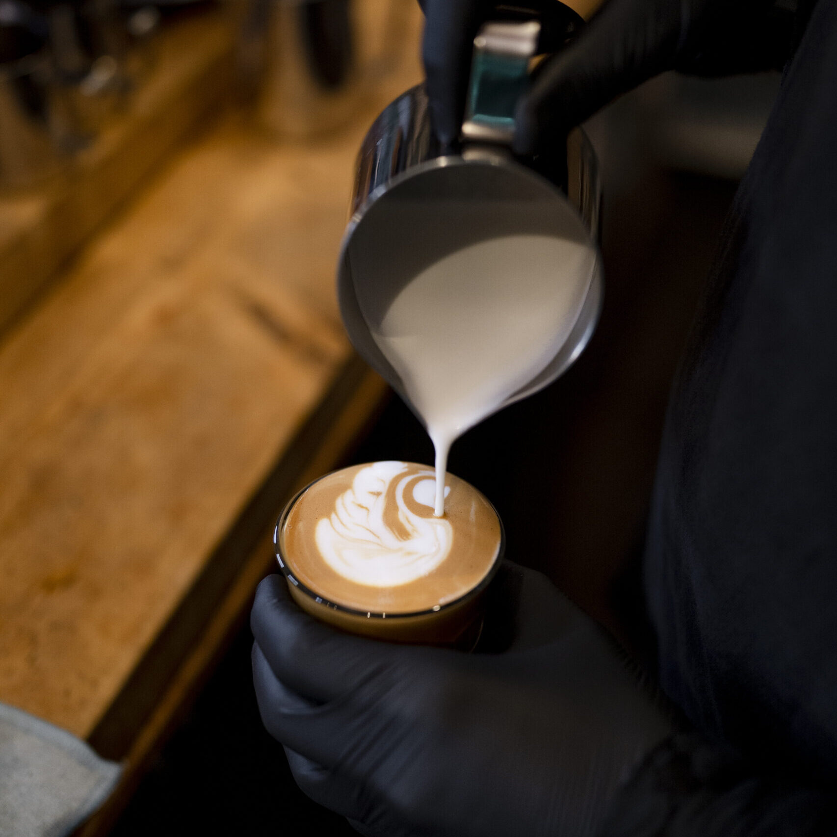 Bild zeigt einen Barista, der eine Kaffeespezialität zubereitet.